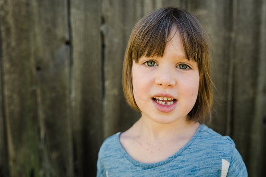 portrait of little girl with a missing bottom tooth