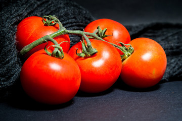 red tomatoes and eggplant on black background