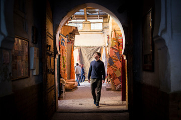 Fototapeta na wymiar man walking through an arab doorway in morocco