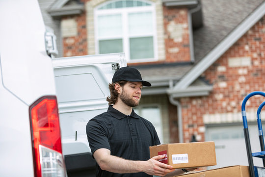 Shipment: Man Putting Box Onto Stack On Dolly