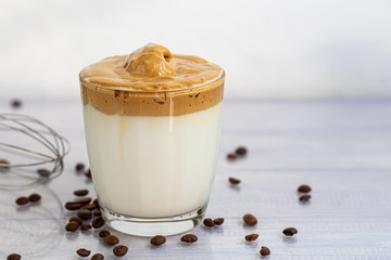 Dalgona coffee is a trendy cold Korean drink. Tasty, aromatic coffee with milk and sugar in a glass on a white background.
