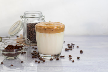 Dalgona coffee is a trendy cold Korean drink. Tasty, aromatic coffee with milk and sugar in a glass on a white background.