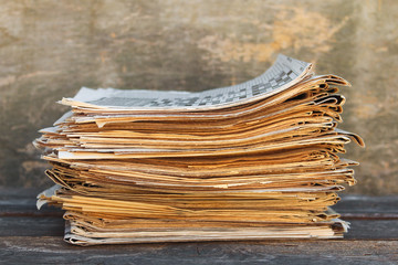 Newspapers and magazines on old wood background.