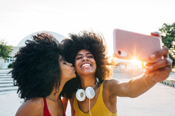 Young women taking selfie on smartphone outdoors