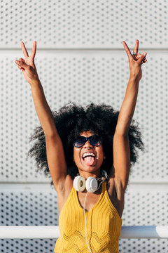 Afro woman showing her tongue in victory pose