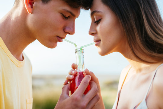 Close Up Of Young Couple Sharing Drink