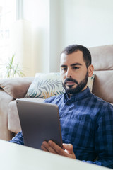 Man surfing on tablet. Looking at digital tablet.