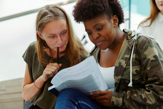 Female students reading task together