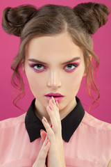 Naklejka premium Nice model woman with fashion makeup on vibrant pink background, beautiful face close up