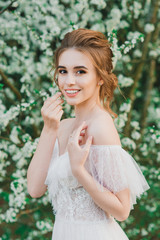 Young beautiful woman in blooming garden. Bride.