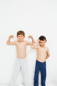 Two brothers showing their hand biceps muscles.