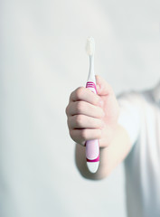 Boy's hand holds a toothbrush in front. Health care, dental hygiene, people and  healthy concept