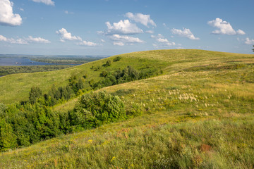 Fototapeta premium hills overgrown with grass and trees on the banks of the Vyatka River