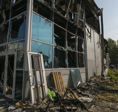Burned construction with broken windows in summer