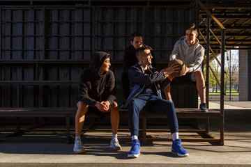 Cheerful athletes sitting on bench during basketball training