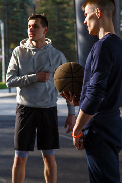 Young men with ball on sports ground