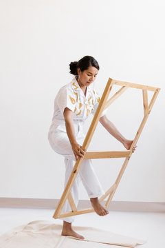 Young Woman Stepping Through A Large Wooden Frame