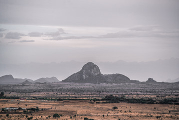 Plakat lone stone mountain across plain in africa