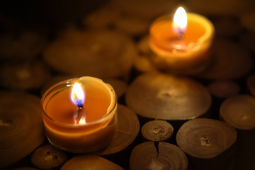 Close-up of burning tealight candle on table in home.