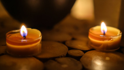 Close-up of burning tealight candle on table in home.