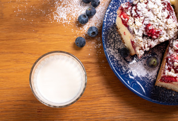 yeast strawberry cake, covered with powder sugar, with glass of milk