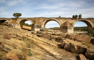 Fototapeta na wymiar ruins of the Ajuda bridge over the Guadiana river in the ancient road between Elvas and Olivenza, Extremadura, Portugal/Spain