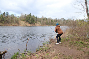 woman with fishing rod on the river