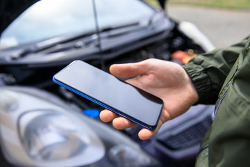 broken car and man hand phone
