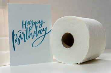 Birthday Greeting Card Sitting Next to Roll of Toilet Paper