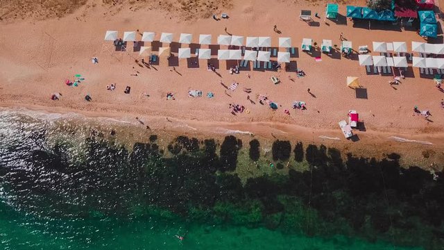 Sandy coast, beach umbrellas and clear turquoise water