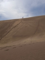Fototapeta na wymiar Climbing a Huge Sand Dune