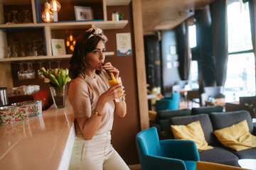 Attractive young caucasian woman drinking juice in cafe