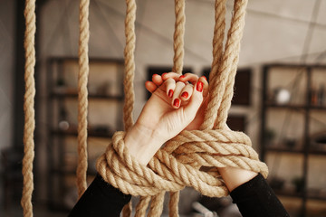 Tied with a rope female hands. Beautiful hands with red nails. Concept of sex or violence