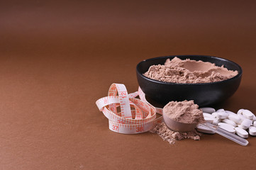 Sports nutrition on a black background. Protein and dietary supplements in powder and in tablets. Free space for text. Copy space