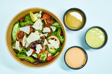 Seafood salad with grilled shrimps, mussels, squid rings, lettuce, cherry tomatoes, Parmesan cheese, capers, avocado and a slice of lemon in an artichoke box