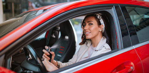 Beautiful caucasian businesswoman puts perfume in car
