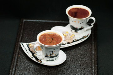 traditional Turkish coffee with Turkish delight. heart shaped saucers and traditional Turkish coffee on black granite   tray in black background. Coffee cups and saucers with the symbols of istanbul.