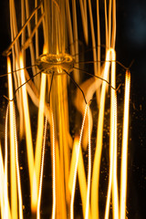 Closeup detail of a tungsten filament lamp. spiral light macro photo. five spiral holders. zigzag...