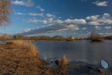 Blue water pond near Budweis city in winter windy sunny day with mirror