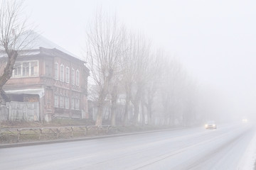 rural road a car hiding in the muddy morning fog