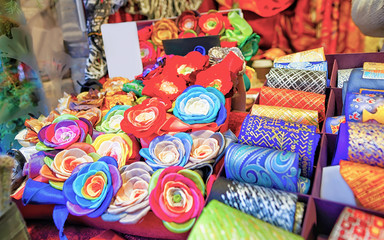 Fototapeta na wymiar Festive handmade ties and flower brooches at Riga Christmas market reflex