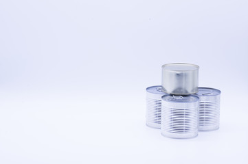 Donation with four cans of canned food on white, peas and corn, food stock for quarantine, isolation period on white. Donation, coronavirus