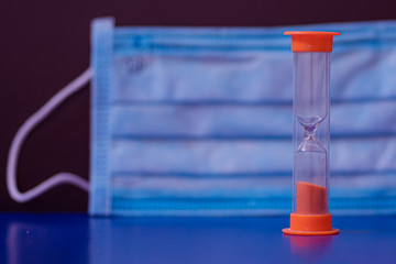surgical mask and hourglass on the background 