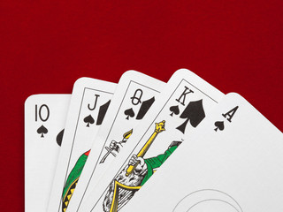 Playing cards. Royal flush on red velvet background