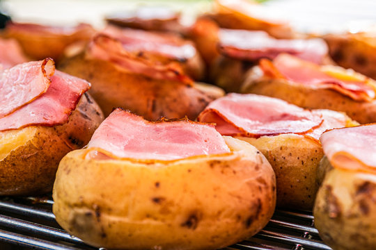 Fresh, delicious potatoes and bacon on grill. Closeup grilling potatoes and bacon on BBQ