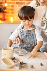 young beautiful family having fun and cooking in the sunny kitchen