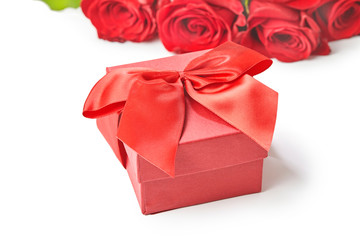 Gift box and red roses on a white background Top view