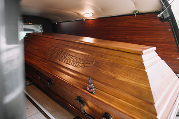 a coffin in the back of a car at a funeral