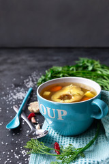 Fresh fish soup with dill and parsley on a blue towel and a dark background. copy space