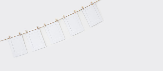 Mock-up marcos de fotos blancos de papel colgados con pinzas de madera